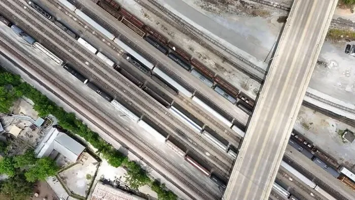 Framed Print : An overhead drone shot captures the railroad tracks as a train passes through Framed Print : An overhead drone shot captures the railroad tracks as a train passes through
