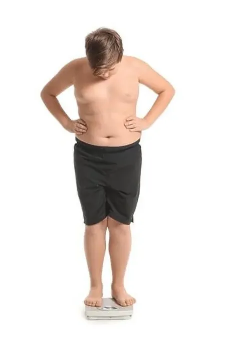 Framed Print : Overweight boy standing on scales against white background Framed Print : Overweight boy standing on scales against white background