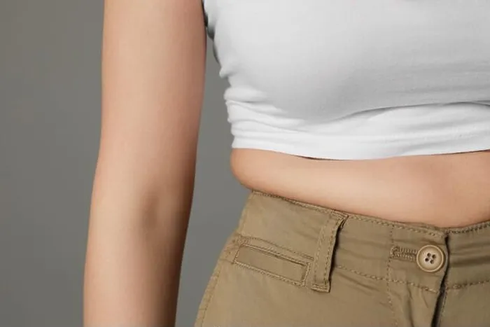 Framed Print : Overweight woman in tight pants on grey background, closeup Framed Print : Overweight woman in tight pants on grey background, closeup