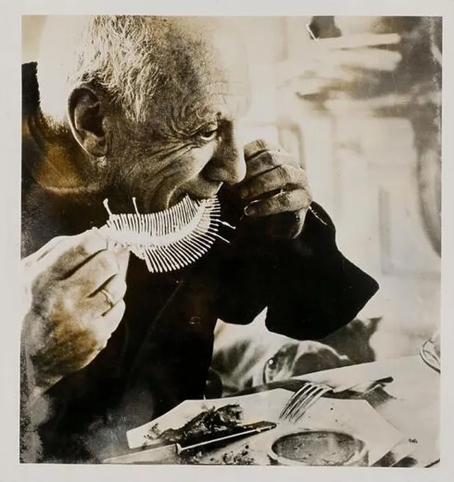 Framed Print : Pablo Picasso eats a fish whose bones are then printed in clay Framed Print : Pablo Picasso eats a fish whose bones are then printed in clay