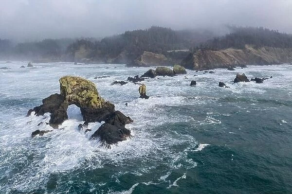 The Pacific Ocean crashes against rocks off the coast of northern Oregon. This wild region, just west of Portland, is often covered by a dark clouds