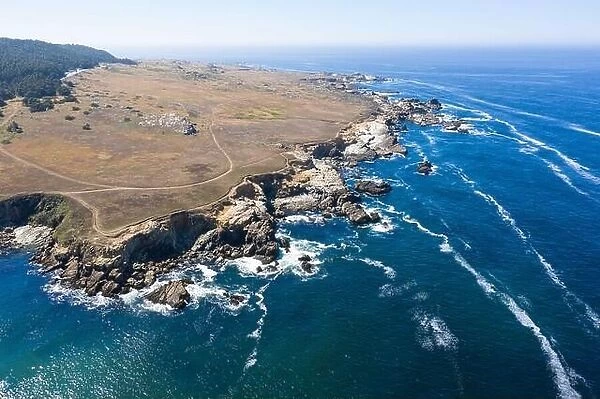 The Pacific Ocean washes along the rugged shoreline of Northern California on a calm day. This is one of the most beautiful areas of the United