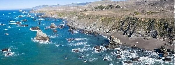 The Pacific Ocean washes against the shoreline of northern California on a beautiful day. The scenic Pacific Coast Highway runs this coastal area