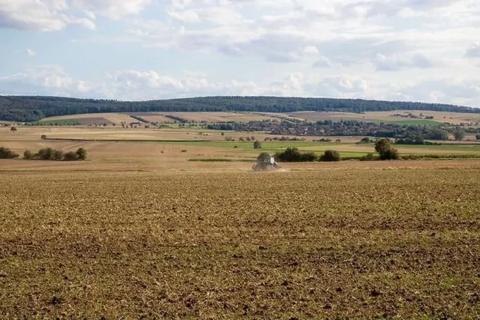 Framed Print : Panorama of a field with a tractor, hilly landscape Framed Print : Panorama of a field with a tractor, hilly landscape