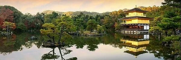 Panorama view of Kinkakuji the famous Golden Pavilion with Japanese garden and pond with dramatic evening sky in autumn season at Kyoto, Japan. Japan
