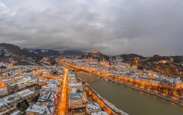 Framed Print : Panoramic aerial drone shot view of snowy Salzburg by river after sunset with heavy clouds after storm rain Framed Print : Panoramic aerial drone shot view of snowy Salzburg by river after sunset with heavy clouds after storm rain