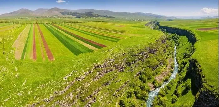 Framed Print : Panoramic aerial view of agricultural fields sown with crops and river in deep canyon