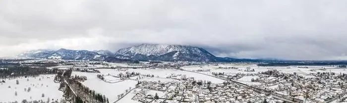 Framed Print : Panoramic aerial view of Austrian mountain half in fog with Anif snowy village in outskirt in the foreground in winter