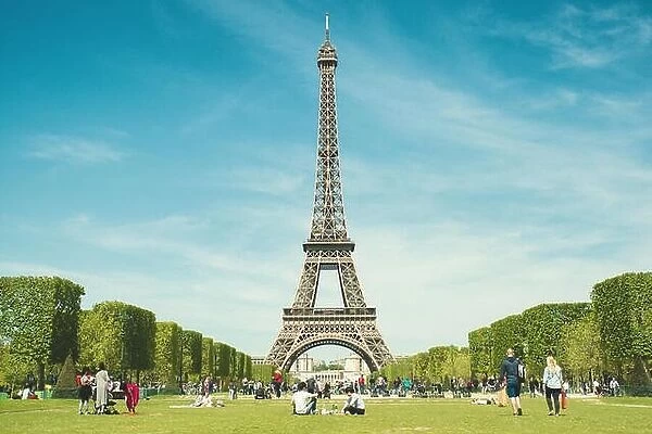 Paris, France - May 6, 2016 : Tourists chilling in park near Eiffel Tower Paris, France. In year 2016 more than 15 million tourists visited the city of