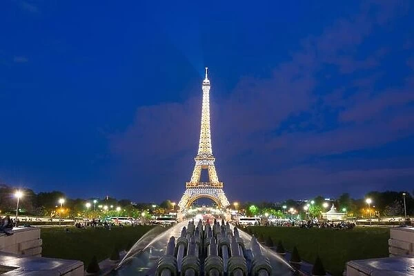 PARIS, FRANCE - May 8, 2016: Tourist sightseeing beautiful night scene of illuminated Eiffel Tower at dusk, Paris, France