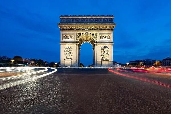 Paris street at night with the Arc de Triomphe in Paris, France