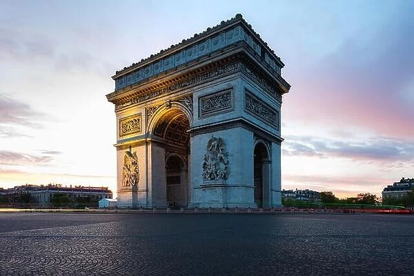 Paris street during sunrise with the Arc de Triomphe in Paris, France