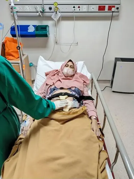 Framed Print : Patient laying on bed receiving medical treatment from nurse with green uniform in intensive care unit room at hospital Framed Print : Patient laying on bed receiving medical treatment from nurse with green uniform in intensive care unit room at hospital