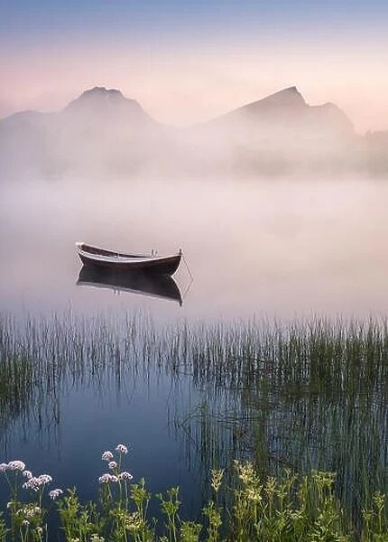 Very peaceful summer night with wooden boat and fog in Lofoten, Norway