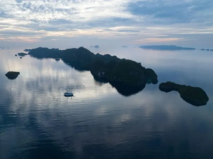 Framed Print : A peaceful sunrise illuminates dramatic limestone islands that rise from Raja Ampat's beautiful seascape. This area has high marine biodiversity Framed Print : A peaceful sunrise illuminates dramatic limestone islands that rise from Raja Ampat's beautiful seascape. This area has high marine biodiversity