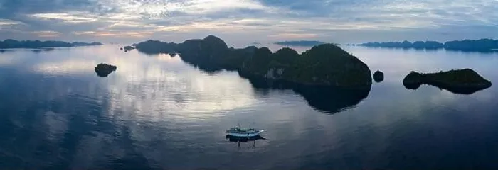 Framed Print : A peaceful sunrise illuminates dramatic limestone islands that rise from Raja Ampat's beautiful seascape. This area has high marine biodiversity Framed Print : A peaceful sunrise illuminates dramatic limestone islands that rise from Raja Ampat's beautiful seascape. This area has high marine biodiversity