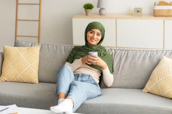Framed Print : Peaceful weekend. Positive young Arab lady in hijab relaxing on sofa with cozy hot drink at home Framed Print : Peaceful weekend. Positive young Arab lady in hijab relaxing on sofa with cozy hot drink at home