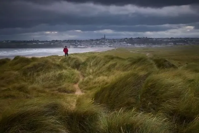 Framed Print : person on some dunes in a protected reserve looking at a city. Tramore, Waterford, Ireland Framed Print : person on some dunes in a protected reserve looking at a city. Tramore, Waterford, Ireland