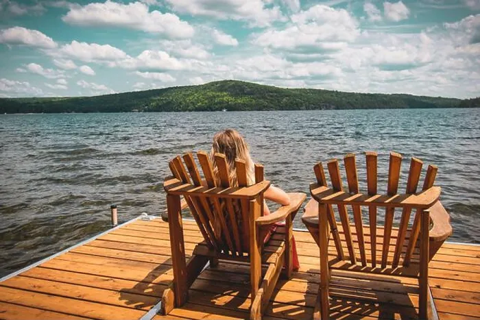 Framed Print : Person resting on a folding chair on a wooden dock on the sea under a cloudy sky and sunlight Framed Print : Person resting on a folding chair on a wooden dock on the sea under a cloudy sky and sunlight