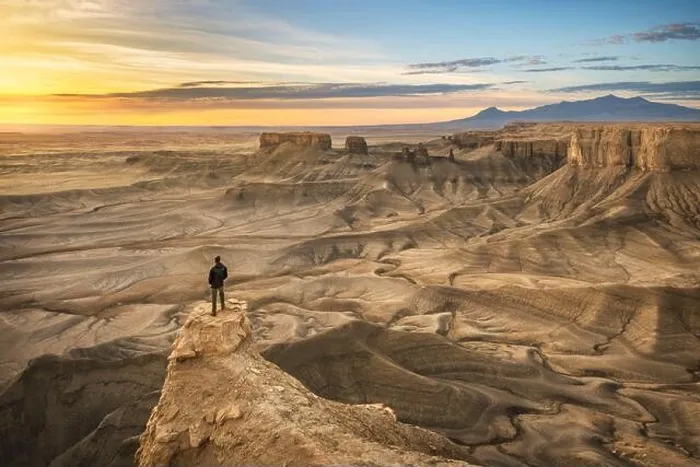 Framed Print : One person standing on rock outcrop in a dramatic desert landscape Framed Print : One person standing on rock outcrop in a dramatic desert landscape