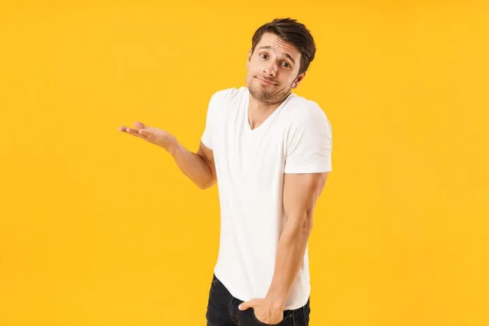 Framed Print : Photo of young man in basic t-shirt looking at camera and throwing up arm isolated over yellow background Framed Print : Photo of young man in basic t-shirt looking at camera and throwing up arm isolated over yellow background
