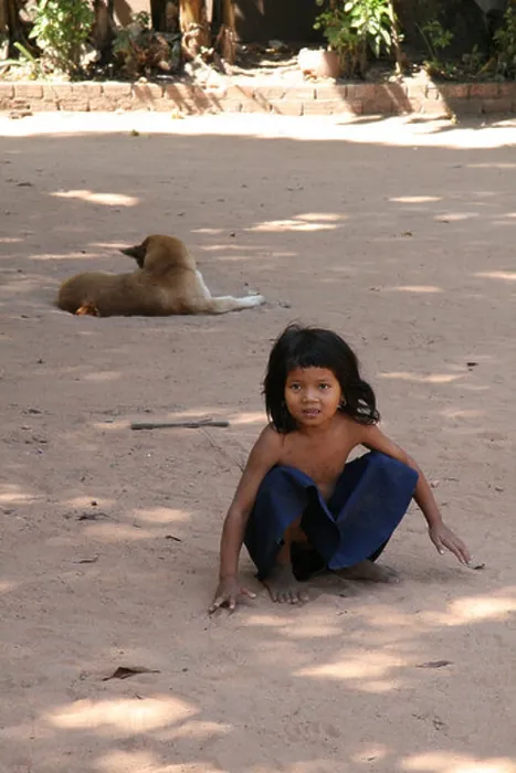 Framed Print : Photograph of a cute Cambodian girl and dog playing near a temple in Siem Reap Framed Print : Photograph of a cute Cambodian girl and dog playing near a temple in Siem Reap