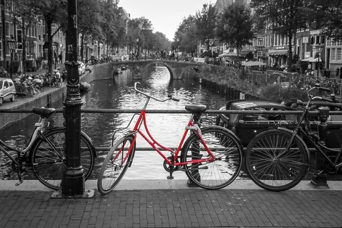 Framed Print : A picture of a red bike on the bridge over the channel in Amsterdam. The background is black and white Framed Print : A picture of a red bike on the bridge over the channel in Amsterdam. The background is black and white