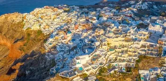 Framed Print : Picturesque Aerial drone view of famous Oia village with white houses during sunrise on Santorini island Framed Print : Picturesque Aerial drone view of famous Oia village with white houses during sunrise on Santorini island