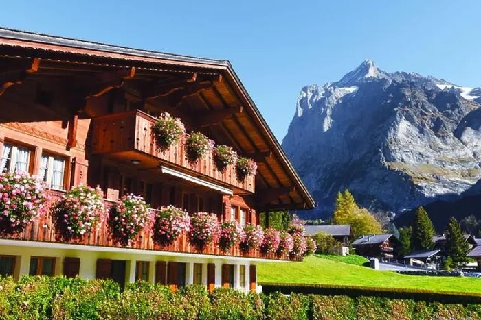 Framed Print : Picturesque autumn landscape with wooden house with flowers and mountains on background in Grindelwald village in Swiss Alps