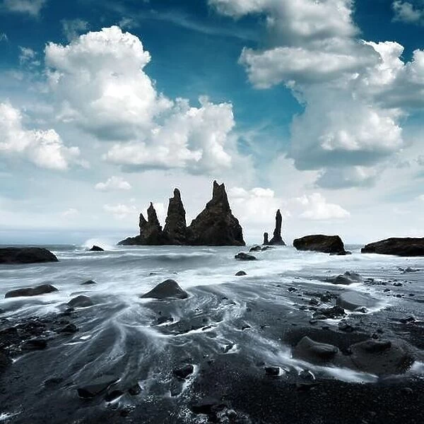 Picturesque landscape with basalt rock formations Troll Toes on Black beach, stormy ocean waves and cloudscape. Reynisdrangar, Vik, Iceland
