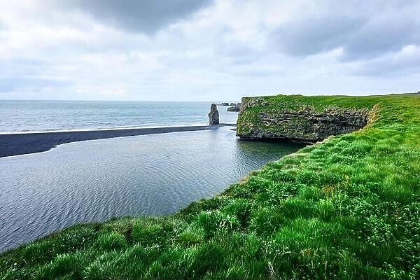Picturesque landscape with green coast of Atlantic ocean in Iceland. Black beach, Reynisdrangar, Vik