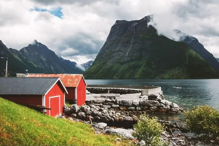 Framed Print : Picturesque scene of Urke village and Hjorundfjorden fjord, Norway. Drammatic sky and gloomy mountains. Landscape photography