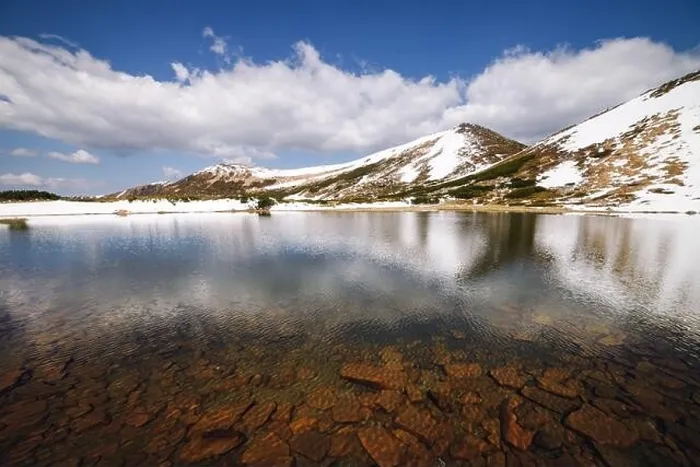 Framed Print : Picturesque spring landscape with snowy hills and clear mountain lake under a blue sky, Carpathian mountains, Europe Framed Print : Picturesque spring landscape with snowy hills and clear mountain lake under a blue sky, Carpathian mountains, Europe