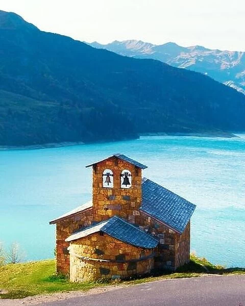 Picturesque view of stone chapel on Roselend lake coast (Lac de Roselend) in France Alps (Auvergne-Rhone-Alpes). Landscape photography