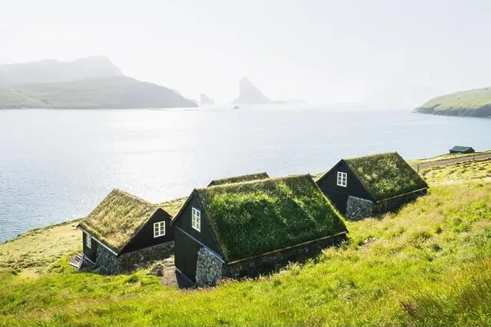 Framed Print : Picturesque view of tradicional faroese grass-covered houses in the village Bour. Drangarnir and Tindholmur sea stacks on background Framed Print : Picturesque view of tradicional faroese grass-covered houses in the village Bour. Drangarnir and Tindholmur sea stacks on background