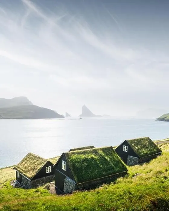 Framed Print : Picturesque view of tradicional faroese grass-covered houses in the village Bour. Drangarnir and Tindholmur sea stacks on background Framed Print : Picturesque view of tradicional faroese grass-covered houses in the village Bour. Drangarnir and Tindholmur sea stacks on background