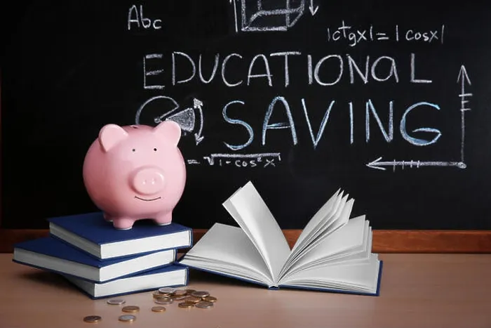 Framed Print : Piggy bank with books and coins on blackboard background. Educational savings concept Framed Print : Piggy bank with books and coins on blackboard background. Educational savings concept