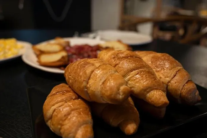 Framed Print : A plate of croissants sits on a table next to a plate of potatoes Framed Print : A plate of croissants sits on a table next to a plate of potatoes