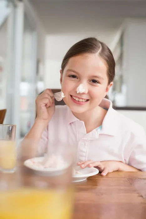Framed Print : Playful girl smearing cake on her nose Framed Print : Playful girl smearing cake on her nose