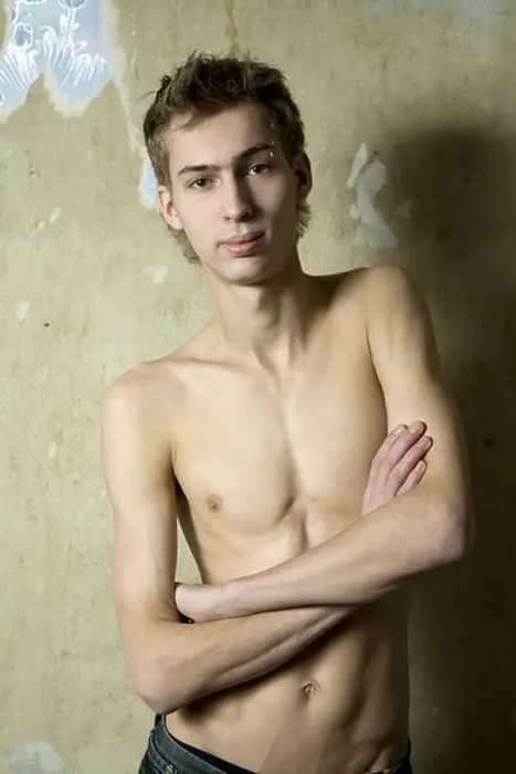 Framed Print : portait of young bare serious man with pirsing in eyebrow standing opposite the wall Framed Print : portait of young bare serious man with pirsing in eyebrow standing opposite the wall