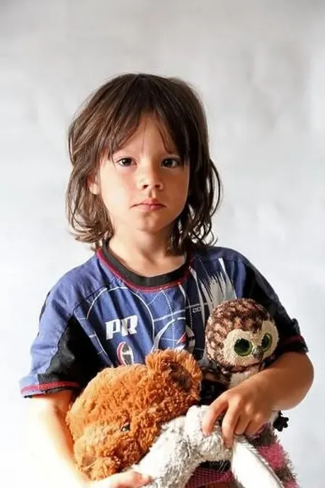 Framed Print : Portrait of 8 year old boy, with long hair wearing his pyjamas and holding some soft toys Framed Print : Portrait of 8 year old boy, with long hair wearing his pyjamas and holding some soft toys