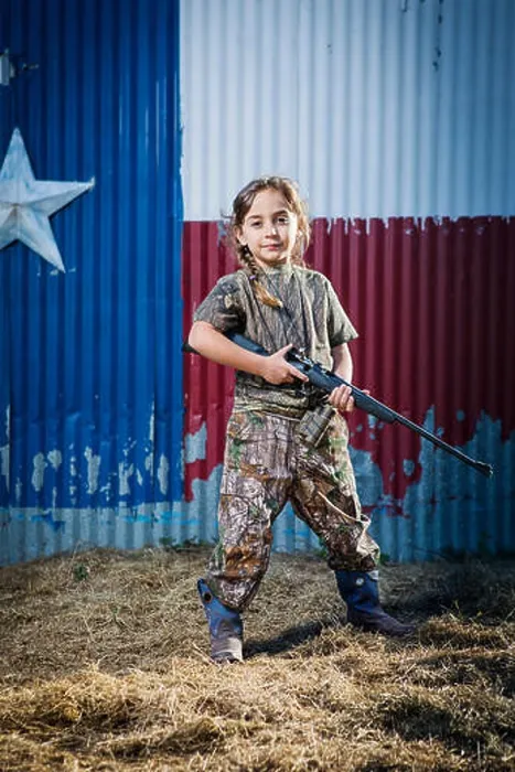 Framed Print : Portrait of confident girl holding rifle while standing on field Framed Print : Portrait of confident girl holding rifle while standing on field