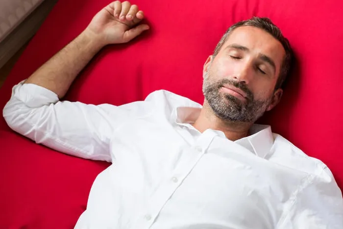 Framed Print : Portrait of a man in a white shirt lying on a red pillow and sleeping Framed Print : Portrait of a man in a white shirt lying on a red pillow and sleeping