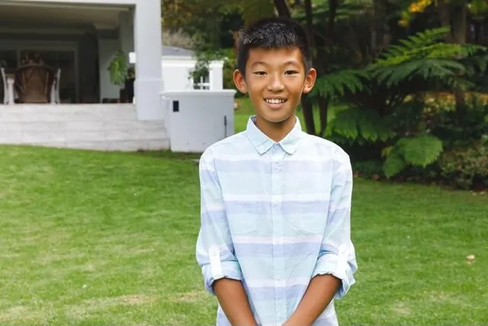 Framed Print : Portrait of smiling asian boy smiling outdoors and wearing casual clothes in garden