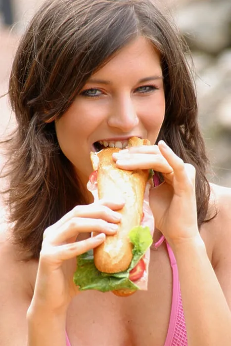 Framed Print : Portrait of a young woman eating hotdog Framed Print : Portrait of a young woman eating hotdog