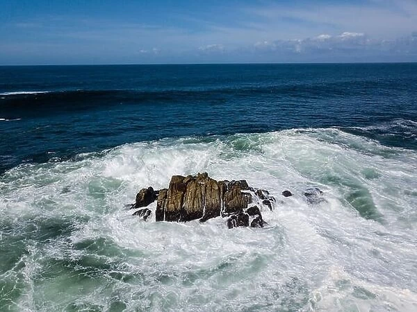 Powerful swells from the Pacific Ocean crash against the rocks just off the coastline of the Monterey peninsula in California
