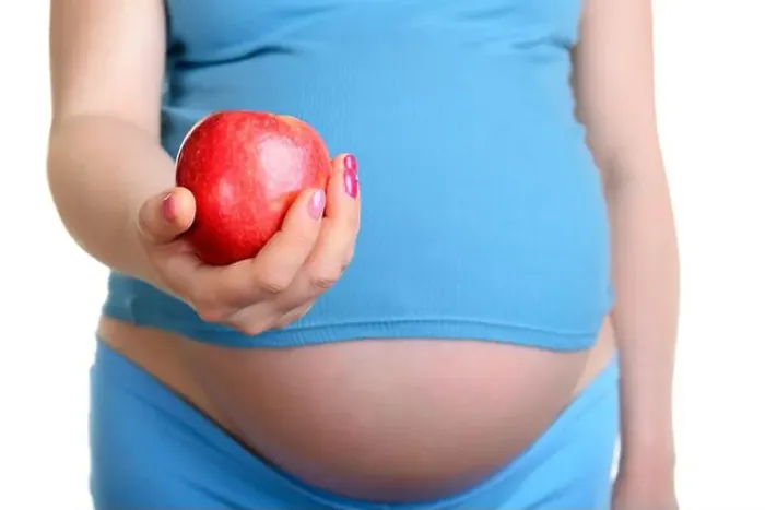 Framed Print : Pregnant woman with red apple isolated on white background Framed Print : Pregnant woman with red apple isolated on white background