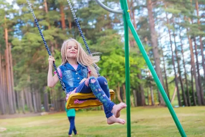 Framed Print : Pretty little blonde girl swinging outdoors on playground Framed Print : Pretty little blonde girl swinging outdoors on playground