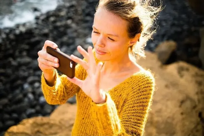 Framed Print : Pretty, young woman taking photos with her smartphone during her vacation Framed Print : Pretty, young woman taking photos with her smartphone during her vacation