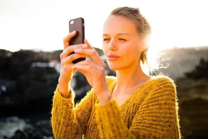 Framed Print : Pretty, young woman taking photos with her smartphone during her vacation Framed Print : Pretty, young woman taking photos with her smartphone during her vacation